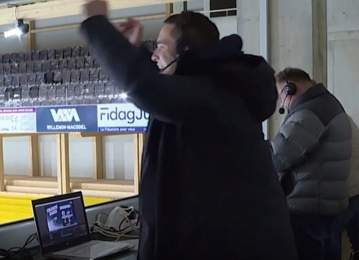 Raphael Walser jubelt mit Headset am Kommentatorenplatz in Pruntrut, vor ihm der Laptop mit dem Logo von «Chloote Radio»